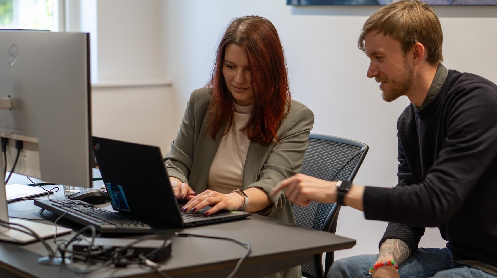 a woman and a man working together on a computer